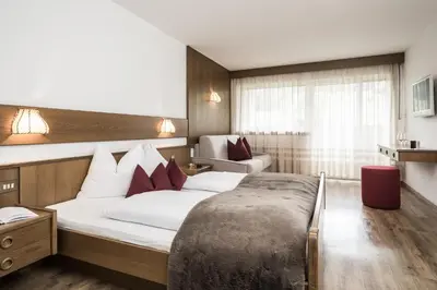 a hotel room with a bed and a couch at Hotel Zum Löwen - Al Leone in Meltina