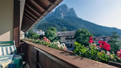 a balcony with flowers and a view of a mountain at Activehotel Diana in Siusi