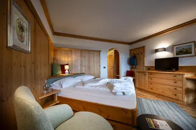 a bedroom with a large bed and a tv at Activehotel Diana in Siusi