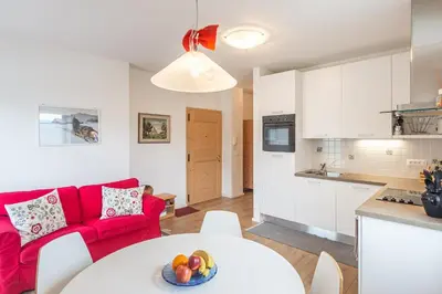 a living room with a red couch and a table at Holiday Apartments Val Moena 1 in Cavalese