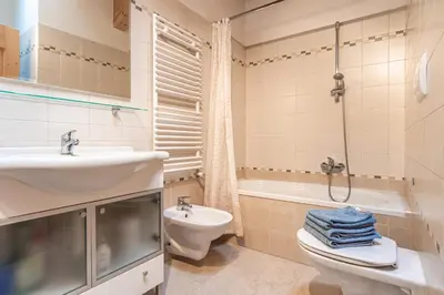 a bathroom with a sink and a toilet and a bath tub at Holiday Apartments Val Moena 1 in Cavalese
