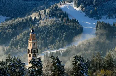 a clock tower in the middle of a mountain at Holiday Apartments Val Moena 1 in Cavalese