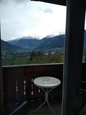 a table on a balcony with a view of mountains at Mühlhaus in Schenna
