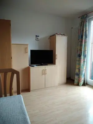 a living room with a flat screen tv on a cabinet at Mühlhaus in Schenna