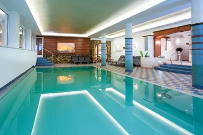 a balcony with a hot tub in a glass wall at Granpanorama Hotel StephansHof in Villandro