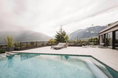 a swimming pool with a view of a mountain at Schenna Resort in Schenna