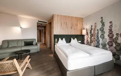 a bedroom with a large bed and a couch at Schenna Resort in Schenna