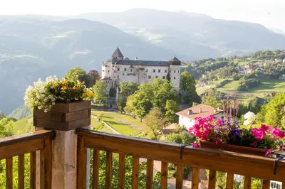 a view of a castle with flowers on a balcony at Schlossblick in Vols am Schlern