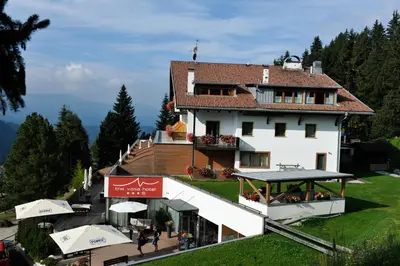 a building on a hill with people walking in front of it at The Vista Hotel in Bressanone