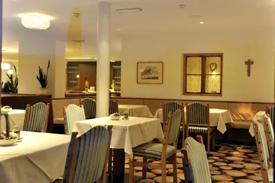 a restaurant with white tables and chairs and a counter at The Vista Hotel in Bressanone