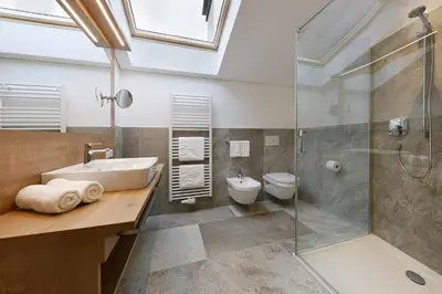 a bathroom with a sink and a shower and a toilet at Garni Oberanger in Tirolo