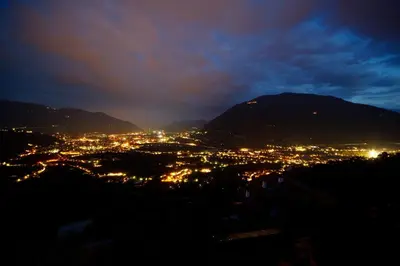 a view of a city at night with a mountain at Garni Oberanger in Tirolo