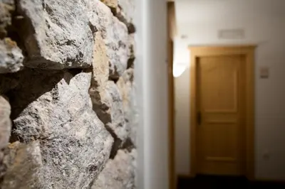 a stone wall with a door in the background at Hotel B&B Pardeller in Nova Levante