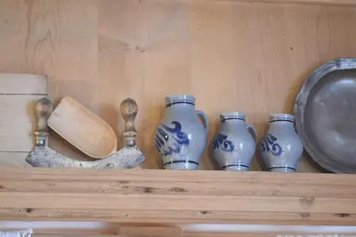 a shelf with blue and white vases and a pan at Hotel B&B Pardeller in Nova Levante