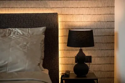 a lamp on a night stand next to a bed at Hotel Finkenhof - Feel at home in Schenna