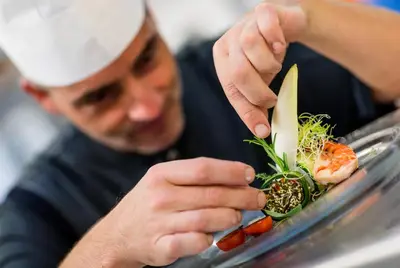 a man in a chefs hat preparing food on a plate at Hotel Finkennest - Panoramic Garden Resort in Schenna
