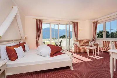 a bedroom with a bed and a living room at Landhaus Hotel Kristall in Marlengo