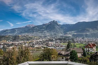 a view of a city with a mountain in the background at Landhaus Hotel Kristall in Marlengo