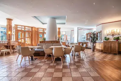a dining room with tables and chairs in a building at Sporting Aparthotel in San Martino di Castrozza