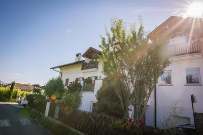 a white house with a fence and a tree at Lochererhof in Appiano sulla Strada del Vino