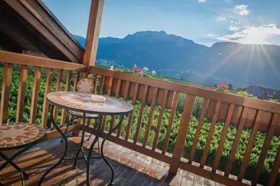 a table and chairs on a deck with a view at Lochererhof in Appiano sulla Strada del Vino