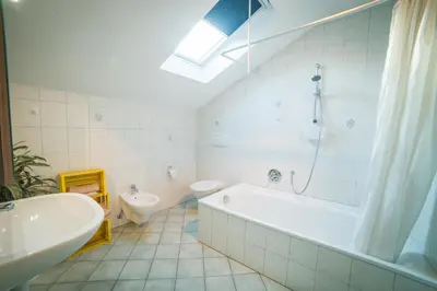 a bathroom with a tub and a toilet and a sink at Lochererhof in Appiano sulla Strada del Vino