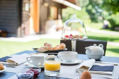 a blue table with breakfast food and a glass of orange juice at Rainell Dolomites Retreat in Ortisei