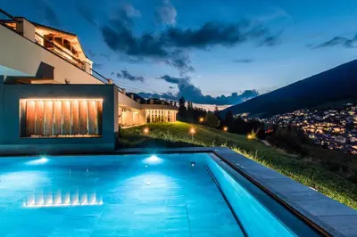 a villa with a swimming pool at night at Rainell Dolomites Retreat in Ortisei