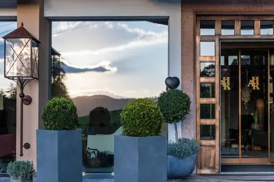 a glass door of a restaurant with plants in front of it at Rainell Dolomites Retreat in Ortisei