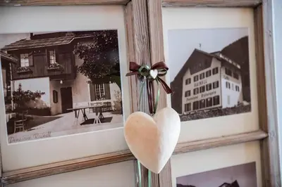 a heart hanging on a wall next to pictures at Rainell Dolomites Retreat in Ortisei