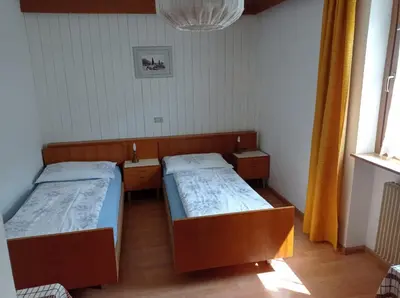 a small room with a bed and a wooden table at Haus Peskoller in Chienes