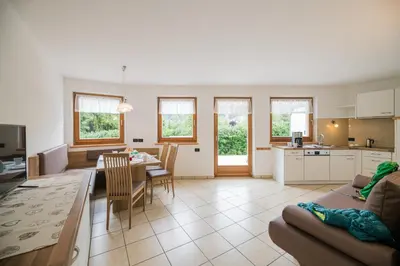a living room with a kitchen and a dining room at PLAN DE CORONES apartments in San Vigilio Di Marebbe