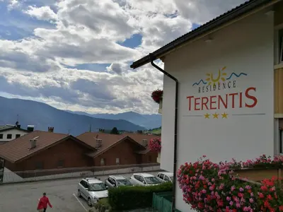 a sign for a restaurant with cars parked in a parking lot at Residence Terentis in Terento