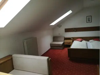 a hotel room with two beds and a couch at Residence Terentis in Terento