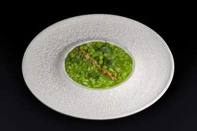 a bowl of peas on a white plate at Villa Eden a member of Leading Hotels of the World in Merano