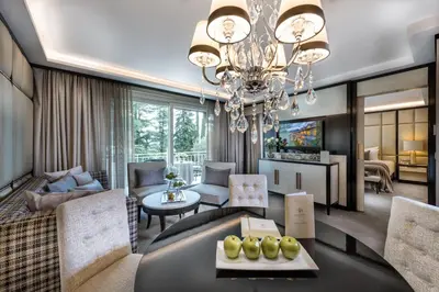 a living room with a chandelier and a dining room at Villa Eden a member of Leading Hotels of the World in Merano