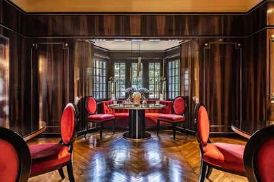 a dining room with red chairs and a table at Villa Eden a member of Leading Hotels of the World in Merano