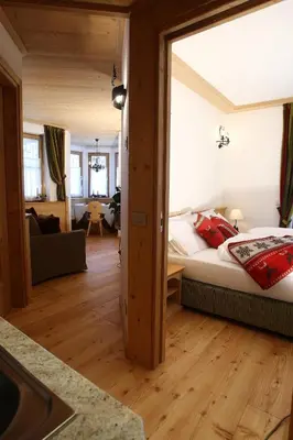 a bedroom with a bed and a living room at Apartments Sol E Nef in Rocca Pietore