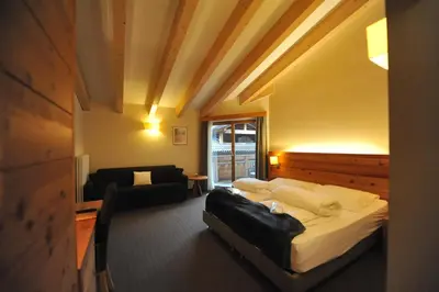 a bedroom with a bed and a living room at Bio Hotel Brusago Vital & Wellness in Bedollo