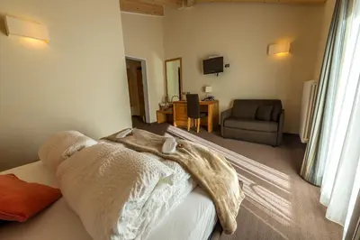 a bedroom with a bed with a blanket on it at Bio Hotel Brusago Vital & Wellness in Bedollo