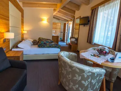 a hotel room with a bed and a couch at Bio Hotel Brusago Vital & Wellness in Bedollo