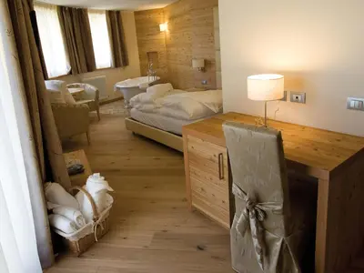 a room with a bedroom with a bed and a desk at Bio Hotel Brusago Vital & Wellness in Bedollo