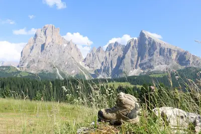a person sitting in a field with mountains in the background at Proderhof in Laion