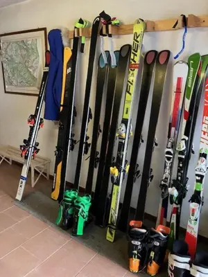 a bunch of skis and snowboards are lined up against a wall at Affittacamere Iragidor in Cortina dʼAmpezzo