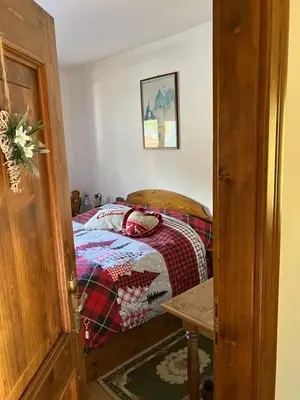a bedroom with a bed with a blanket on it at Affittacamere Iragidor in Cortina dʼAmpezzo