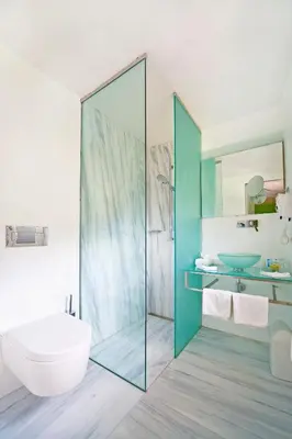 a bathroom with a glass shower and a sink at Hotel Goldener Stern in Caldaro