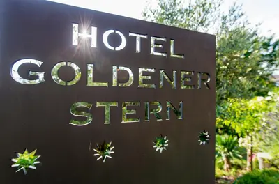 a sign for a hotel colerger sign at Hotel Goldener Stern in Caldaro