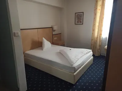 a bedroom with a white bed in a room at Hotel Goldener Stern in Caldaro