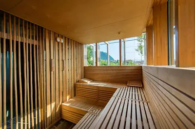 a room with wooden benches in a building with windows at Hotel Goldener Stern in Caldaro