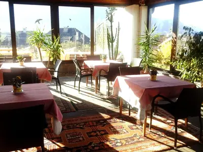 a restaurant with tables and chairs and large windows at Landhaus Weingut in Cornaiano